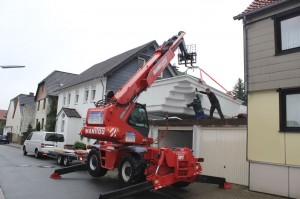 Mit einem Kran wurde dass Schwimmbecken über die Garagen gehoben.
