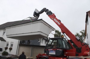 Mit einem Kran wurde dass Schwimmbecken über die Garagen gehoben.