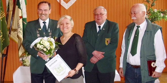 Der Präsident des KSV Goslar (Hartmut Richter) bei der Überreichung des Gutscheines an Jolyn Beer, mit auf dem Bild der Kreisschießsportleiter Andreas Grubert und der ebenfalls geehrte Waldemar Sodtke.