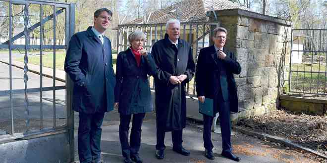 Oberbürgermeister Dr. Oliver Junk, Geschäftsführerin LIEMAK Immobilien GmbH Sylva Viebach, Klosterkammerpräsident Hans-Christian Biallas und Max Stumpf (BIMA) vor dem geöffneten Tor zum Wohnquartier
