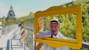 Bürgermeister Ralf Abrahms schaut durch das neue Fenster auf dem Baumwipfelpfad in eine glückliche Zukunft
