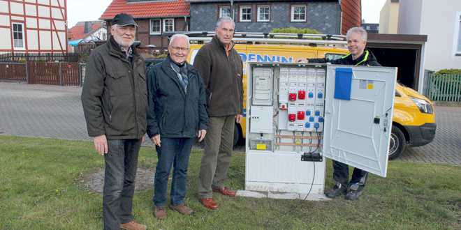 Franz-Josef Knak, Bodo Friedrichs und Hans-Joachim Michaelis von der Dorfgemeinschaft Wiedelah mit Andreas Dennin vor dem neuen Verteilerkasten