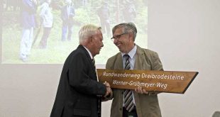 Dr. Hans-Ulrich Kison übergibt ein Duplikat des Wanderwegeschildes an Werner Grübmeyer - Foto: Mandy Bantle, Nationalpark Harz